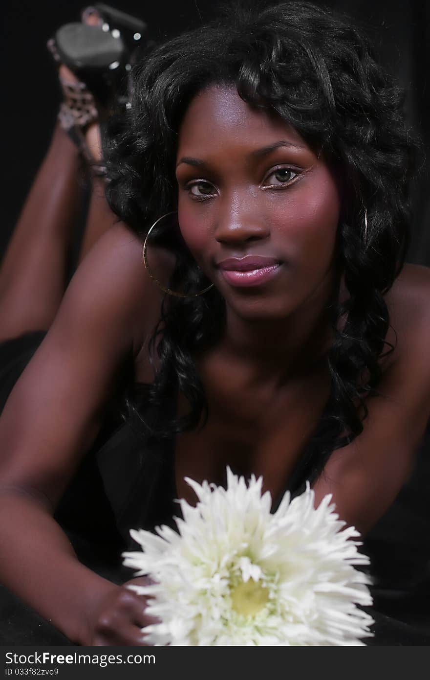 A sexy African American woman with a large flower. A sexy African American woman with a large flower