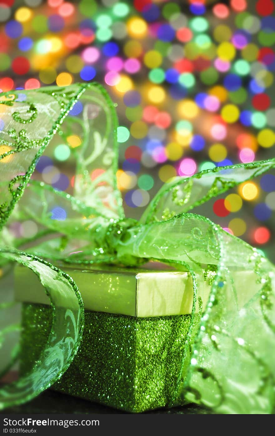 Gift box with green ribbon on a bokeh buckground. Gift box with green ribbon on a bokeh buckground