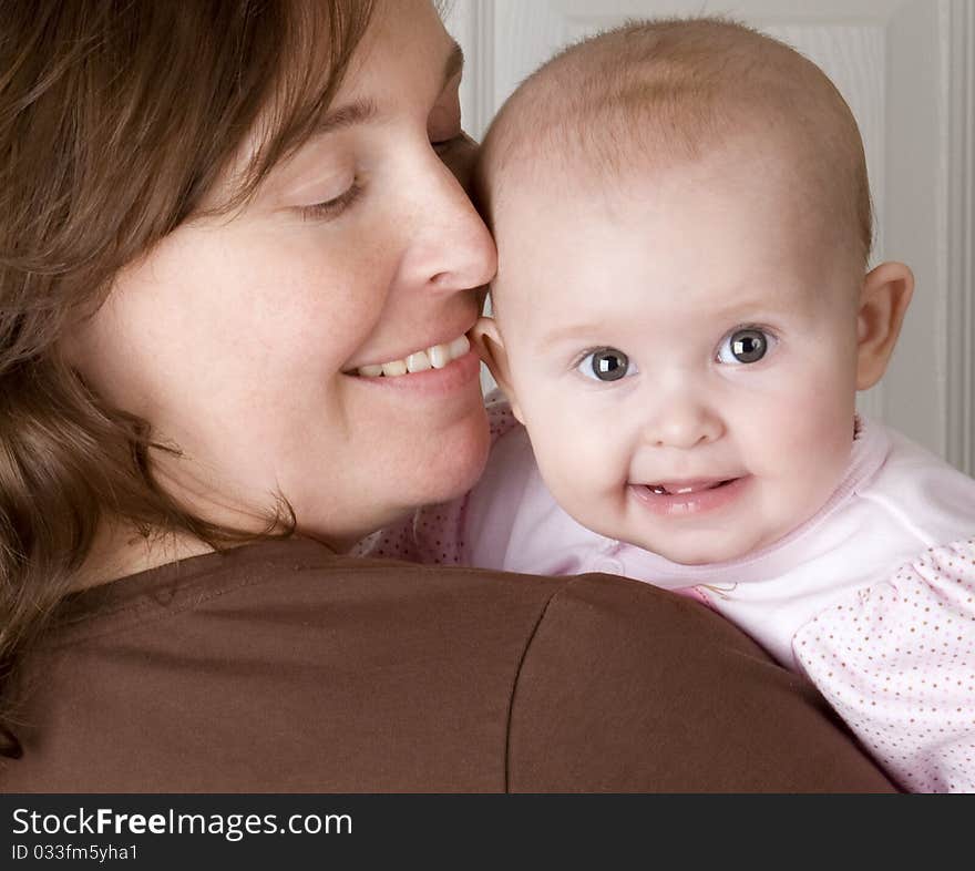 Smiling mother holding her baby girl. Smiling mother holding her baby girl.