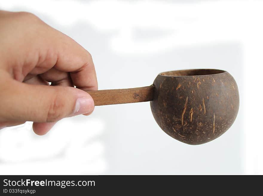 Wooden scoop on hand.