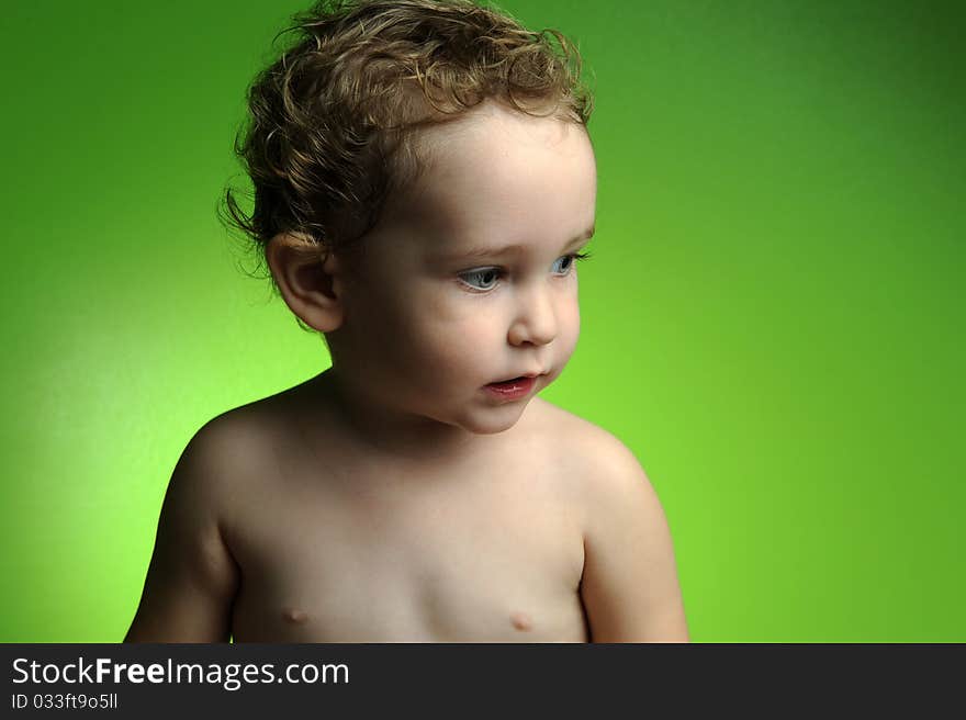 Close up portrait of cute little boy on green background