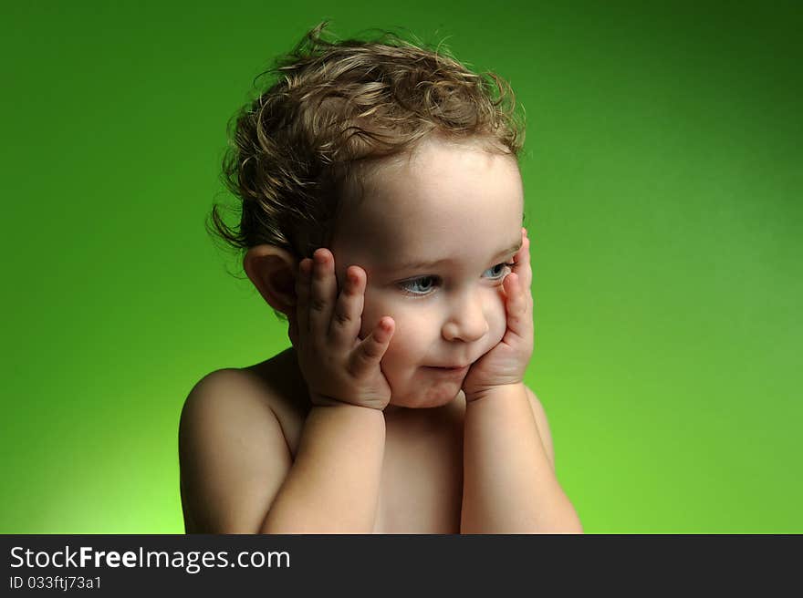 Close up portrait of cute little boy on green background