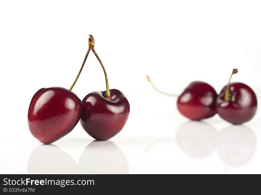 Four red cherries isolated against a white background. Four red cherries isolated against a white background