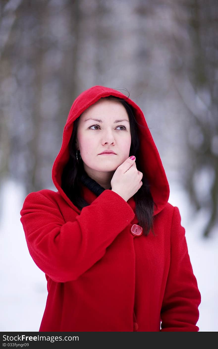 Thoughtful pretty girl in the red coat in winter