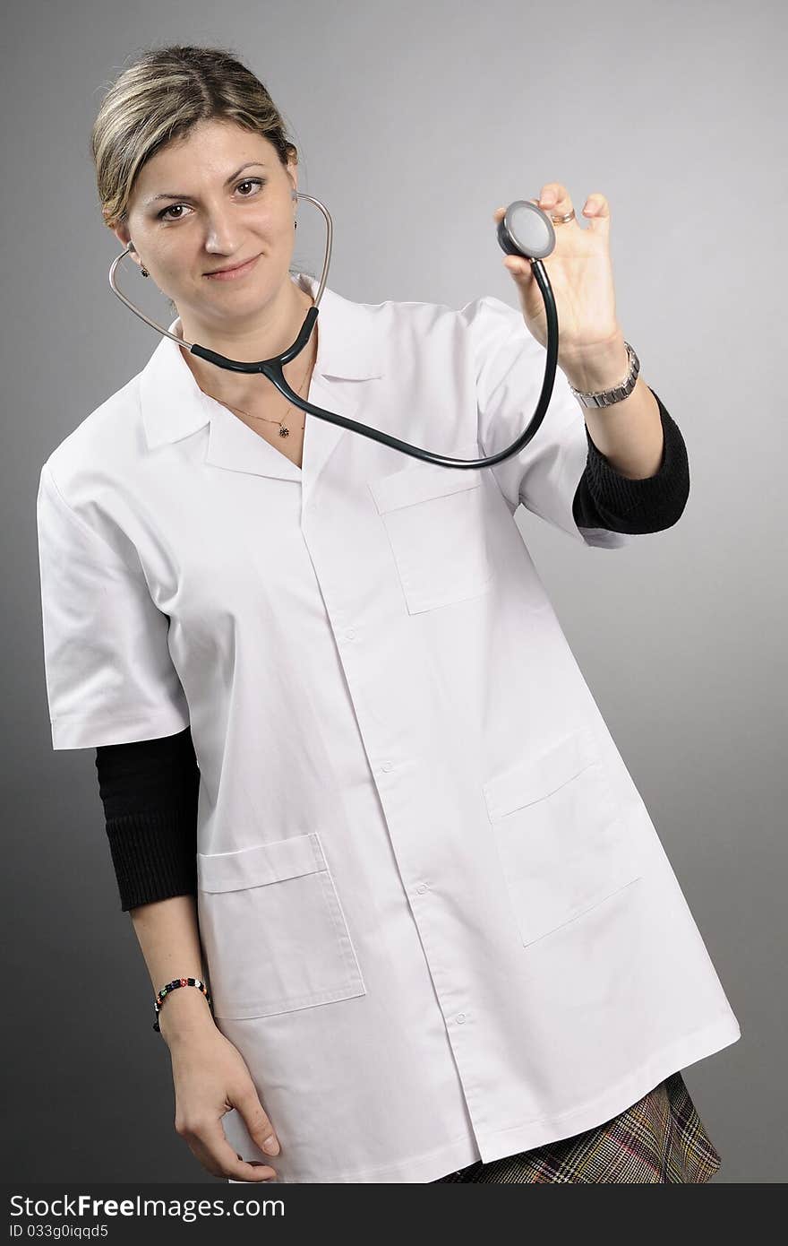 Young doctor posing with stethoscope in studio. Young doctor posing with stethoscope in studio