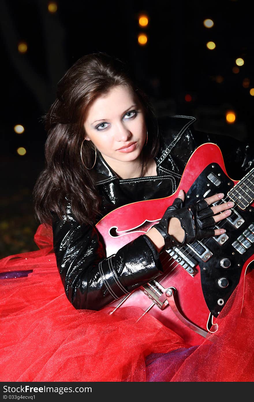 Brunette guitar player girl in the night city