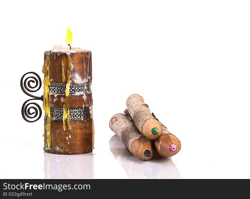 Candle and wooden pencils isolated on white. Candle and wooden pencils isolated on white