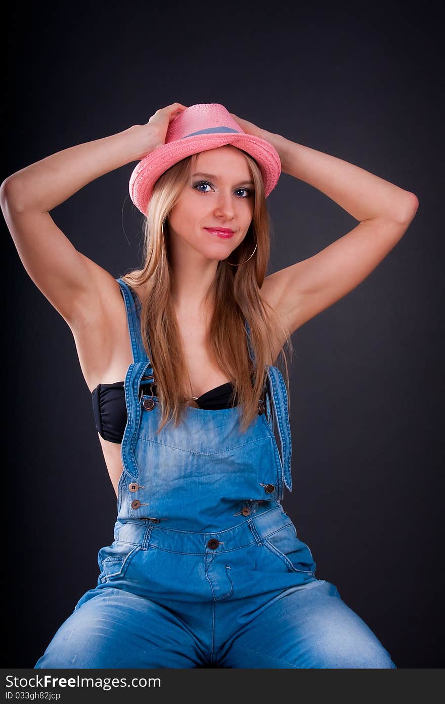 Pretty girl in pink hat and jeans overalls