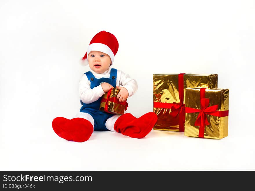 Little boy in Santa hat with a bunch of gifts