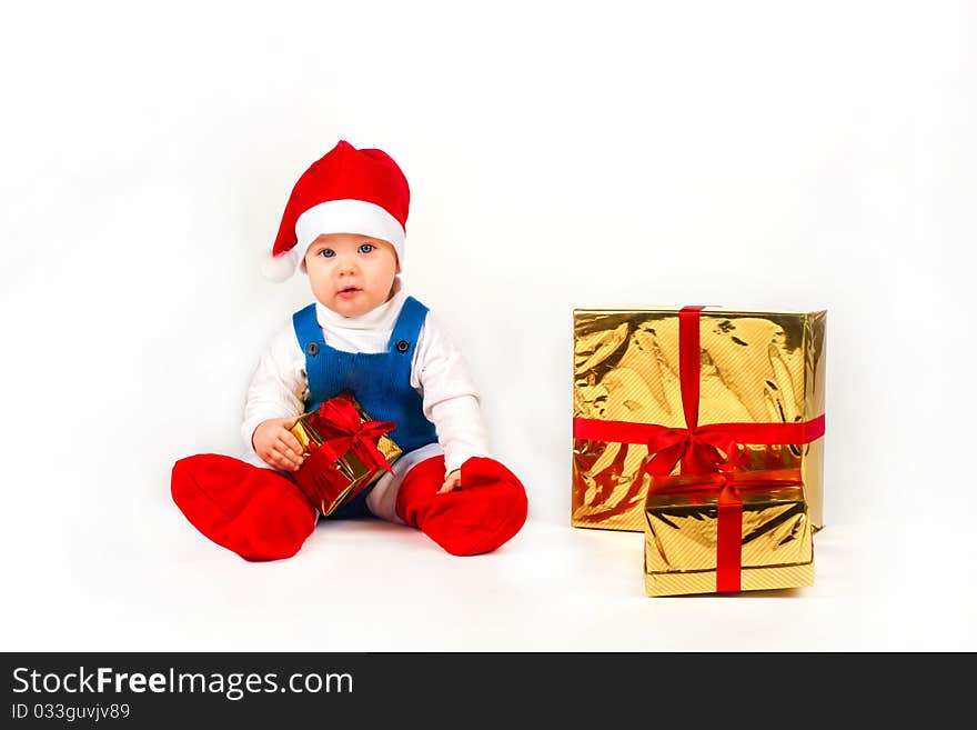 Little boy in Santa hat with a bunch of gifts