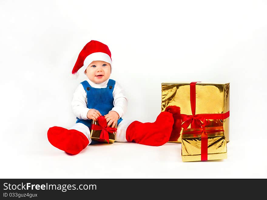 Little boy in Santa hat with a bunch of gifts