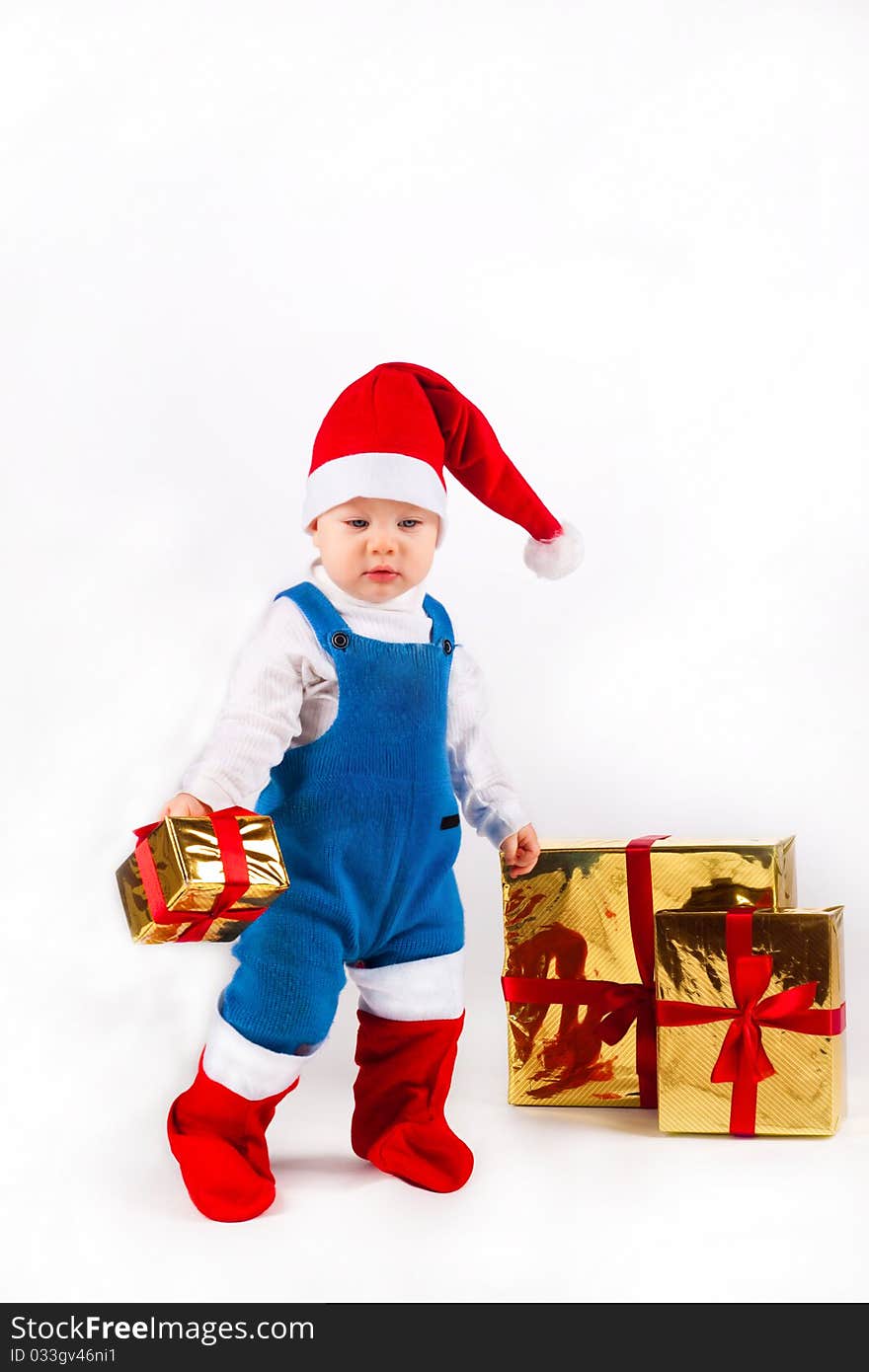 Happy little boy in Santa hat with a bunch of gifts, holiday Christmas, New Year