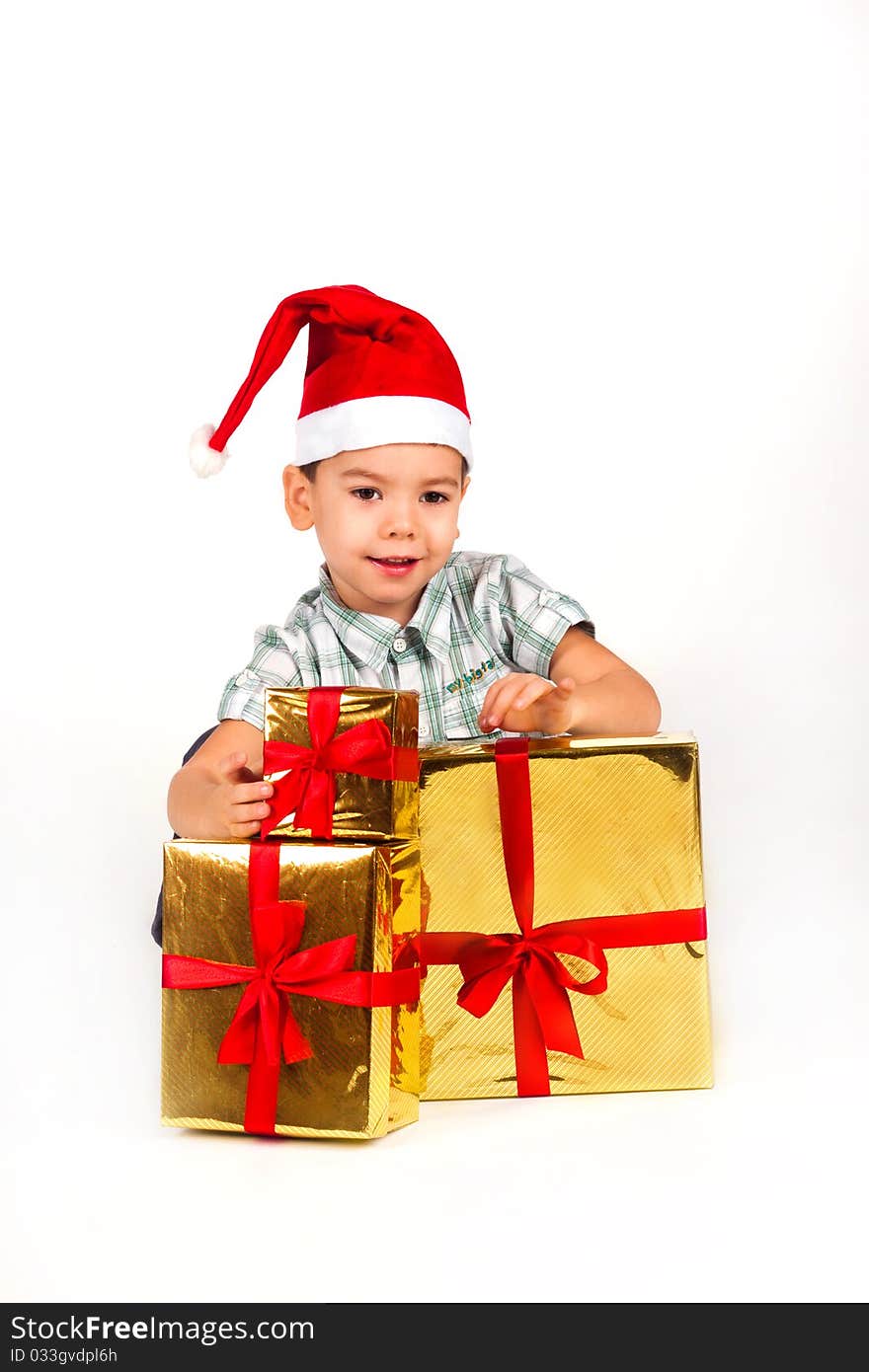 Happy little boy in Santa hat with a bunch of gifts, holiday Christmas, New Year