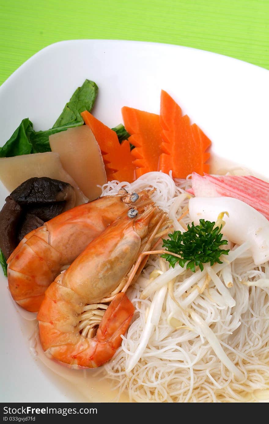 Chinese style seafood noodles in a white bowl