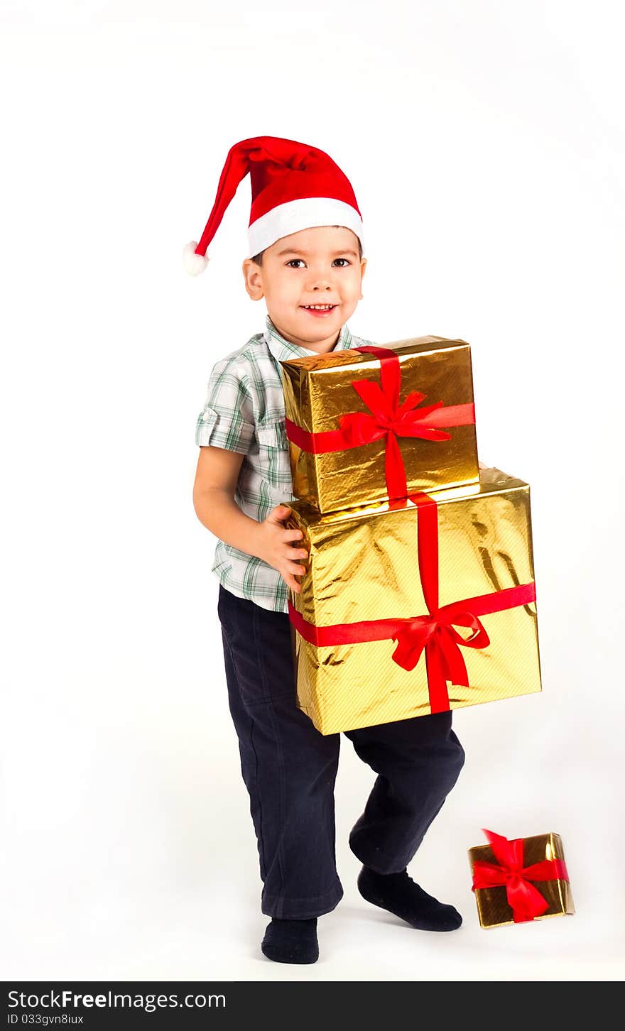 Happy little boy in Santa hat with a bunch of gifts, holiday Christmas, New Year