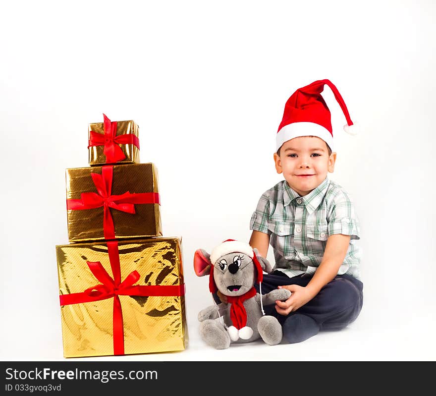 Happy little boy in Santa hat with a bunch of gifts, holiday Christmas, New Year