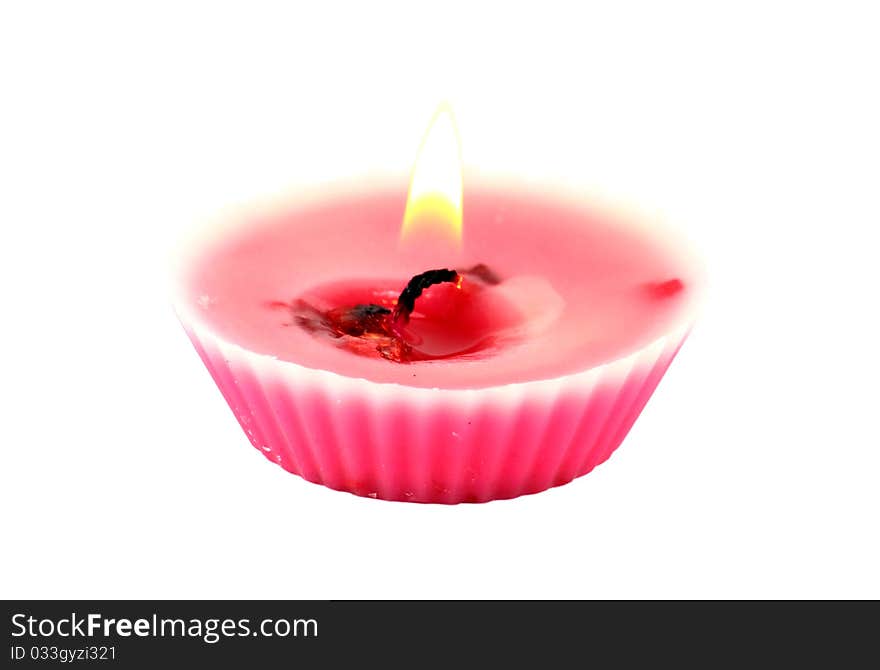 A burning pink candle isolated on white background