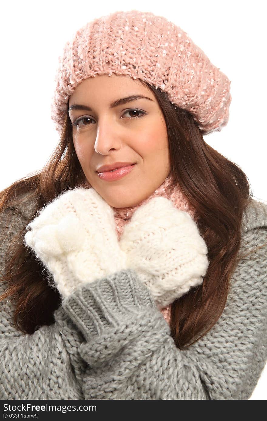 Close up of a beautiful young woman hugging herself wrapped up warm in winter woollies, including mits, hat, scarf and jumper. Close up of a beautiful young woman hugging herself wrapped up warm in winter woollies, including mits, hat, scarf and jumper.