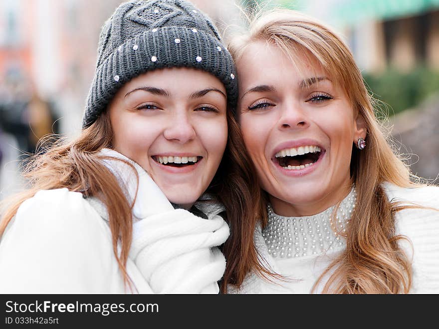 Two cheerful girls twins, in the street