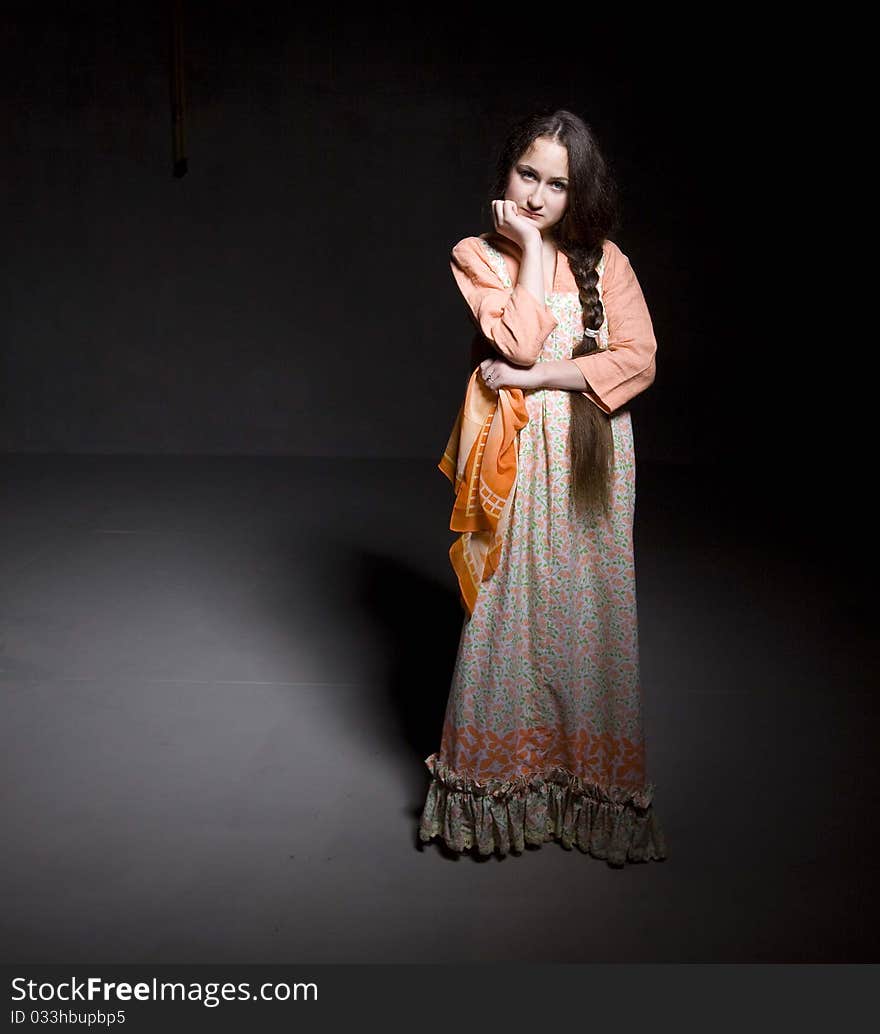 Portrait of a beautiful young girl with long braid.  Taken in a studio setting. Black background. Portrait of a beautiful young girl with long braid.  Taken in a studio setting. Black background.