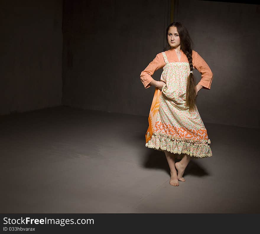 Portrait of a dancing girl in ethnic dress. Taken in a studio setting. Black background.