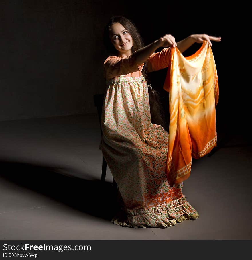 Portrait of beautiful young girl with a shawl. Ethnic russian dress. Taken in a studio setting. Black background. Portrait of beautiful young girl with a shawl. Ethnic russian dress. Taken in a studio setting. Black background.