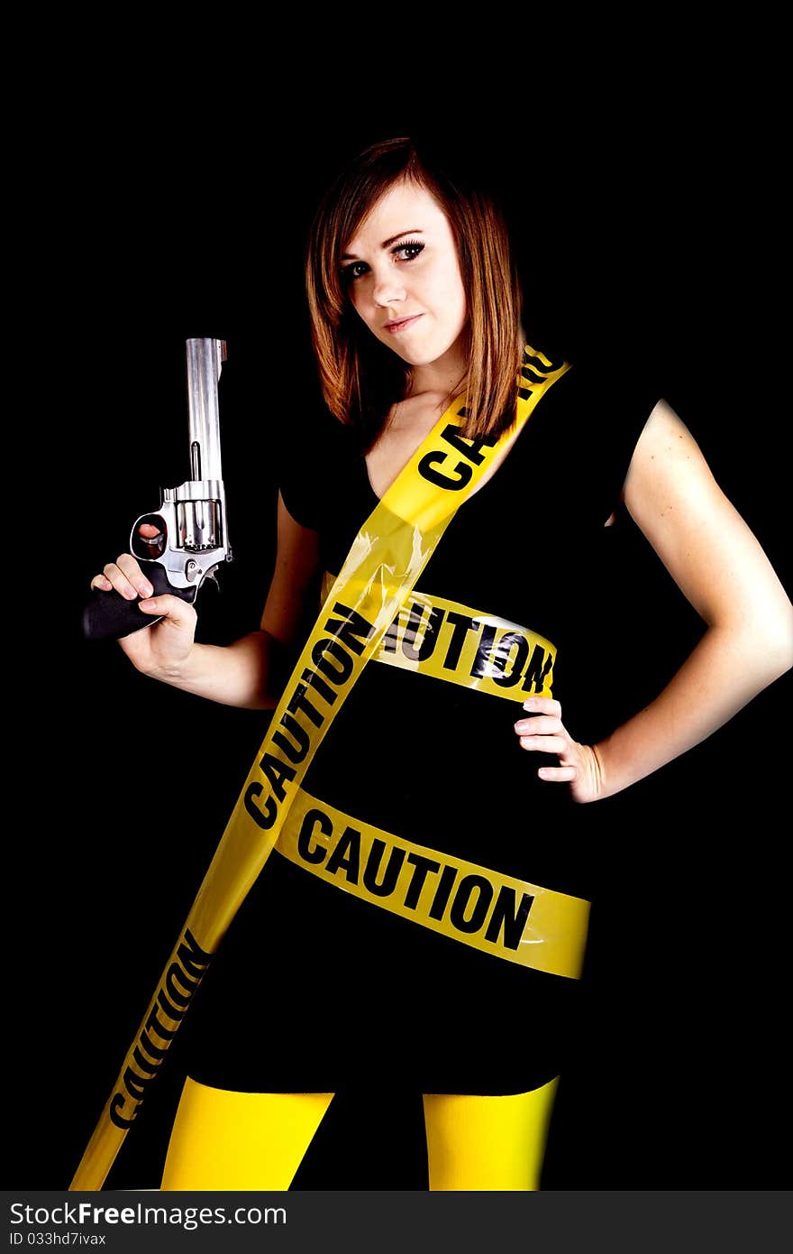 A woman holding a gun on a black background with caution tape wrapped around her. A woman holding a gun on a black background with caution tape wrapped around her.