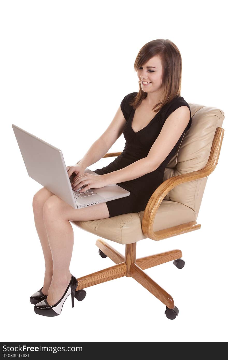 A woman working on her computer with a happy expression on her face. A woman working on her computer with a happy expression on her face.