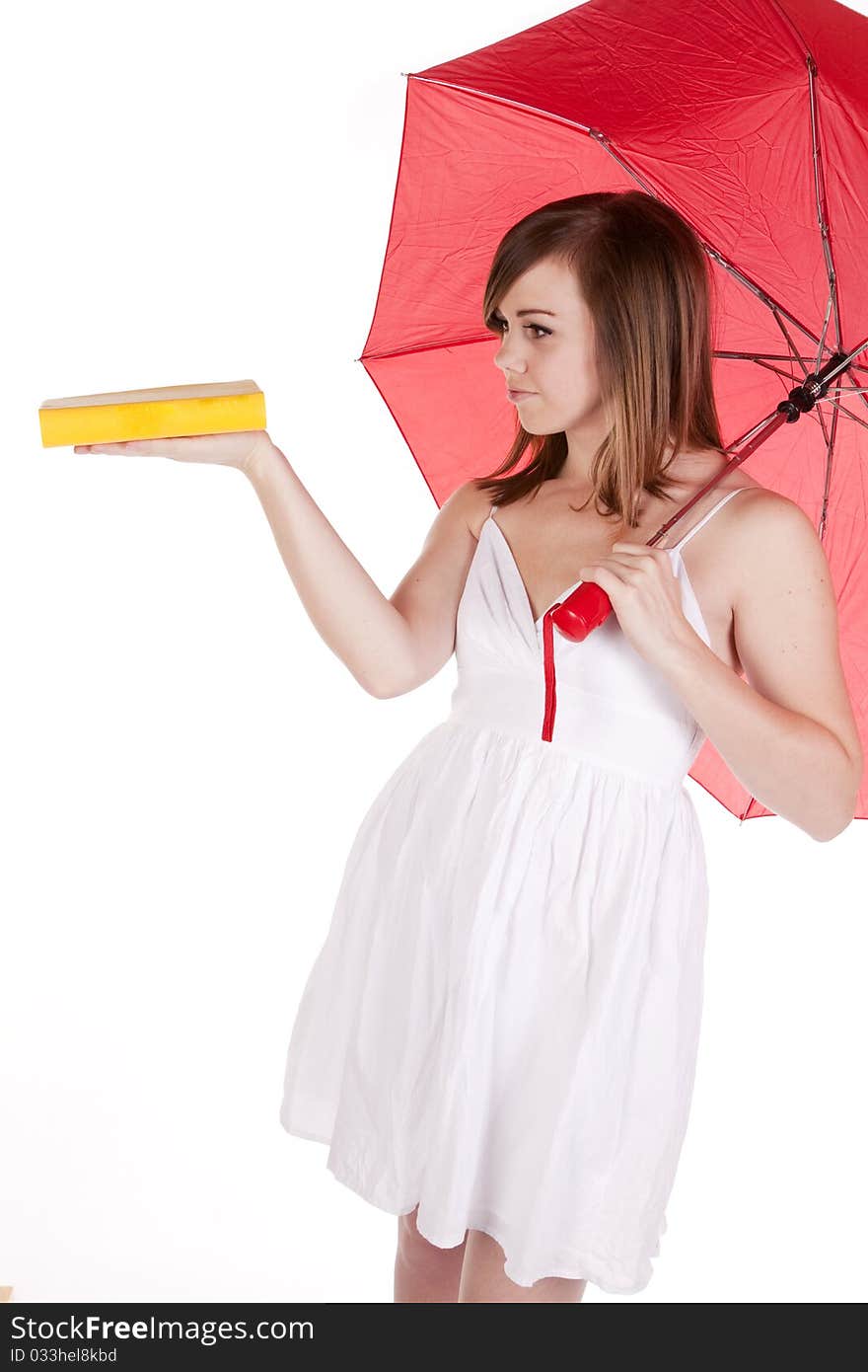 A woman under a red umbrella holding her yellow book out on her hand. A woman under a red umbrella holding her yellow book out on her hand.