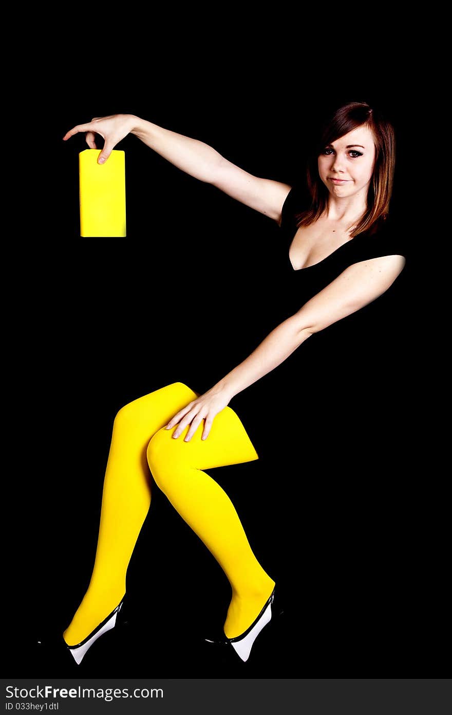 A woman wearing yellow tights in front of a black background wanting to get rid of her boring book. A woman wearing yellow tights in front of a black background wanting to get rid of her boring book.