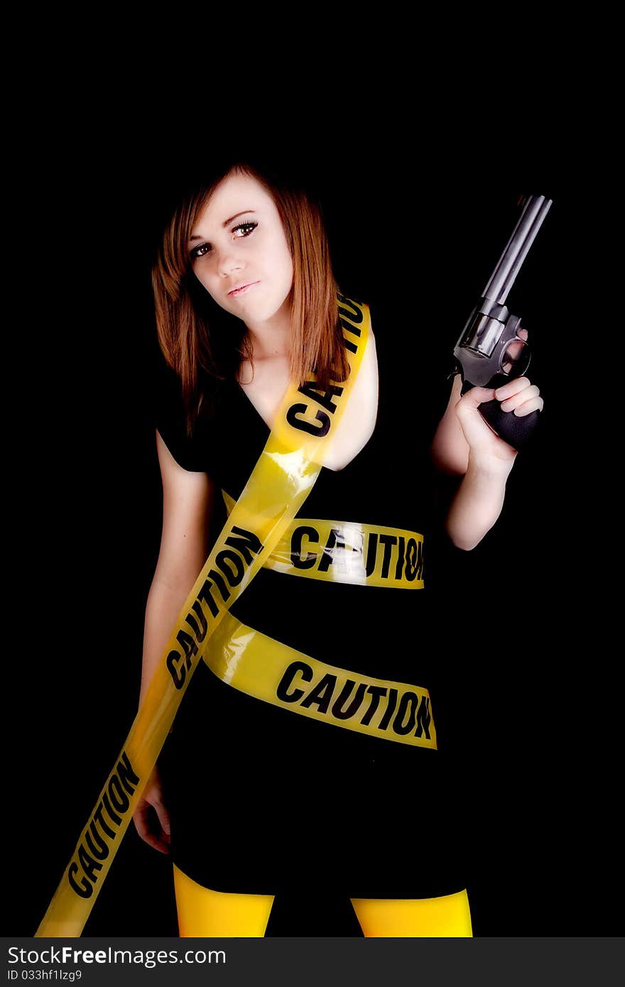 A woman holding a gun on a black background with caution tape wrapped around her. A woman holding a gun on a black background with caution tape wrapped around her.