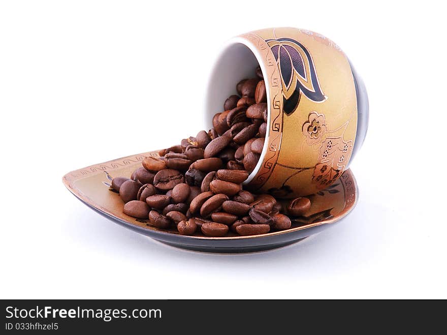 Coffee beans on a plate isolated on white background