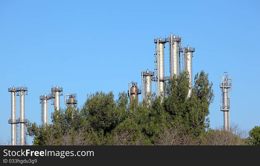 Many towers in an oil refinery over blue sky