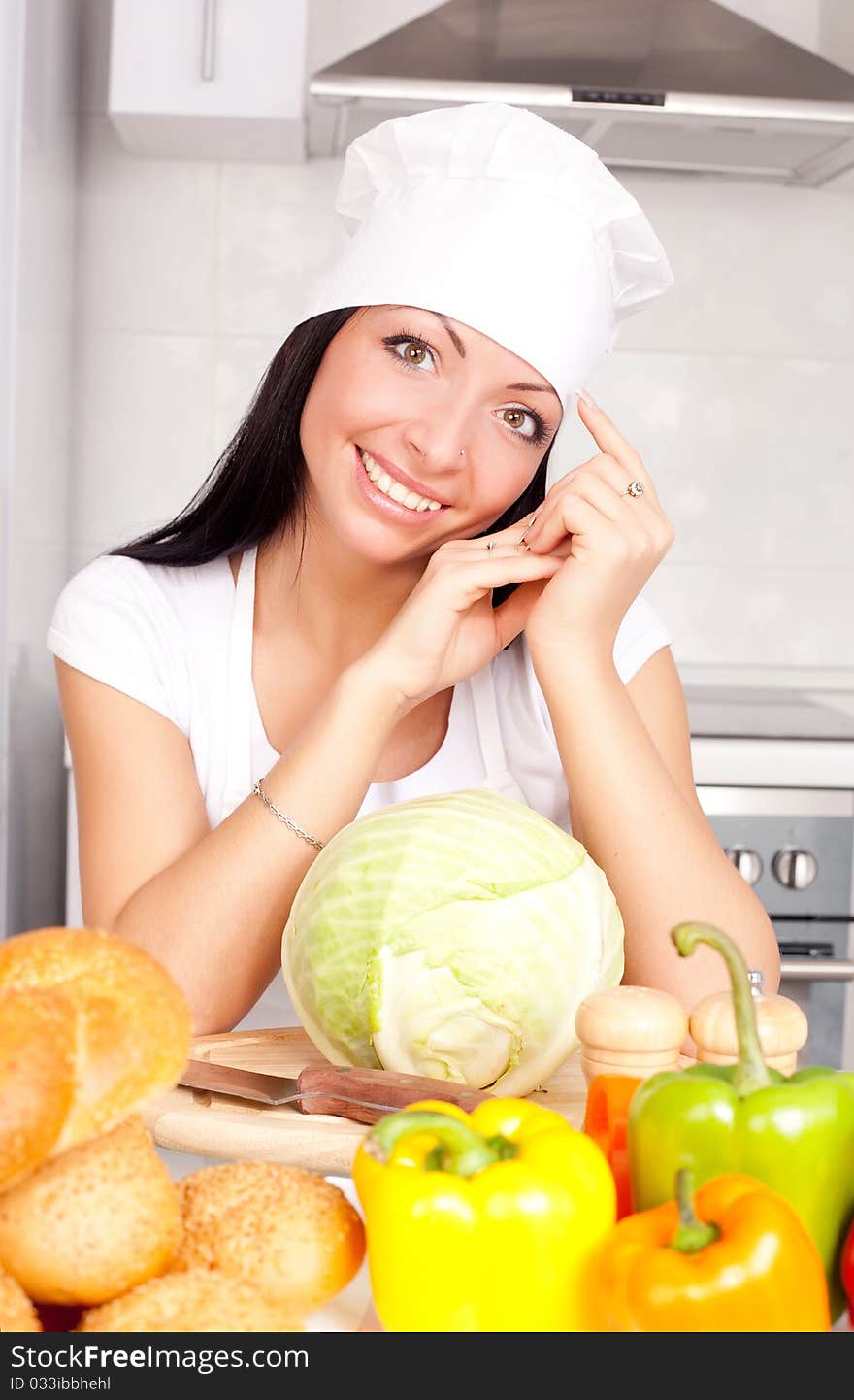 Beautiful young cook with  vegetables in the kitchen. Beautiful young cook with  vegetables in the kitchen