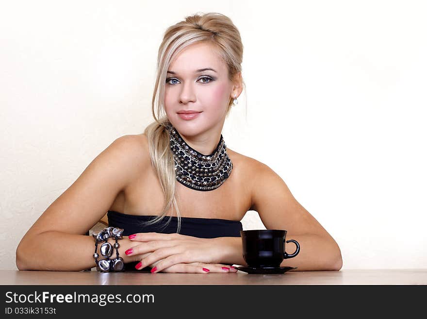 Woman with cup of hot drink against yellow wall at home