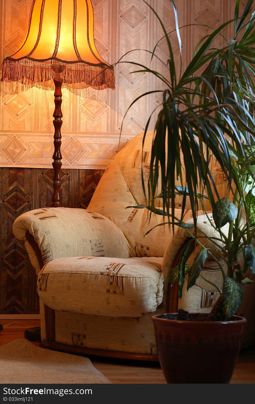 Home interior with luminous floor lamp near armchair and flower pot. Home interior with luminous floor lamp near armchair and flower pot