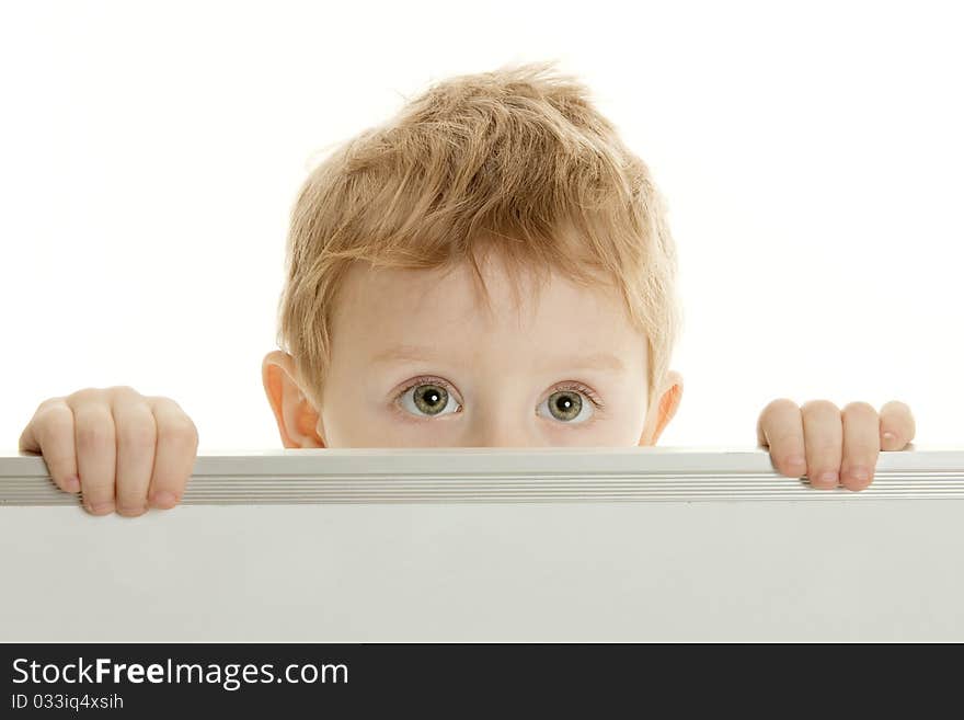 The little boy with the big eyes looks out because of a bulletin board