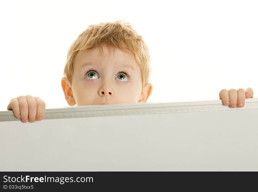 The little boy has control over a bulletin board and looks upwards. The little boy has control over a bulletin board and looks upwards