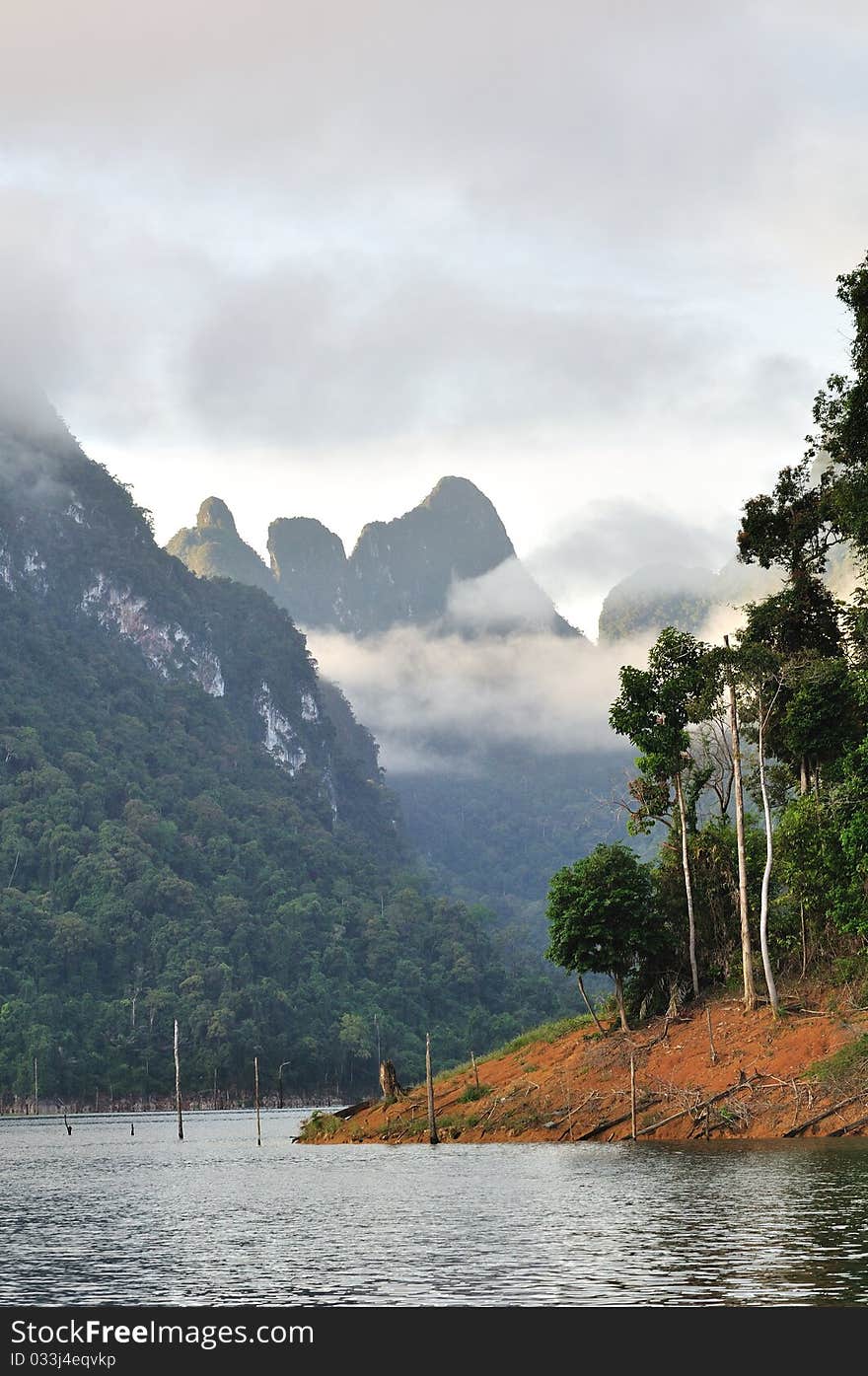 Beautiful lake view with limestone mountain and mist in morning.