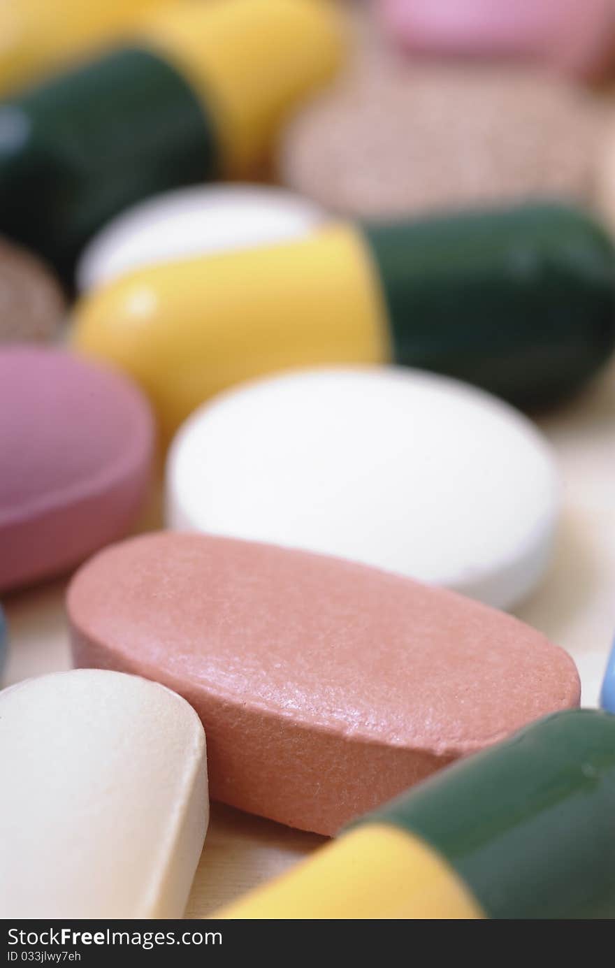 Pills scattered on a wooden board