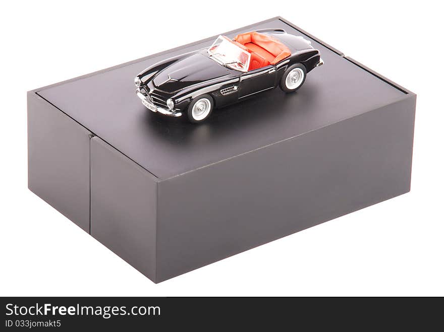 Black vintage toy car on a stand isolated on a white background