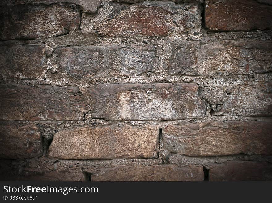 Stone wall grungy texture texture background pattern, with a lens vignette effect.