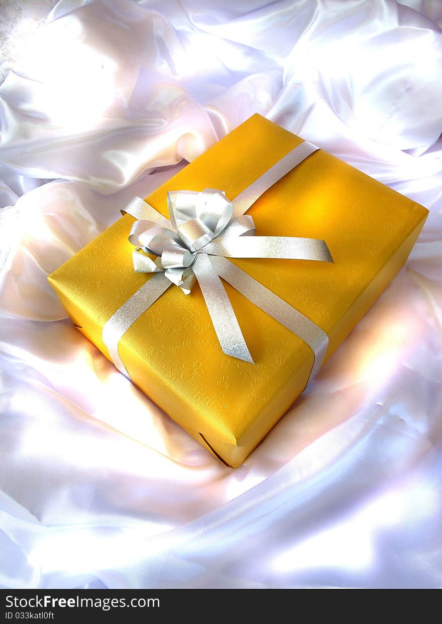 Yellow gift on the white cloth