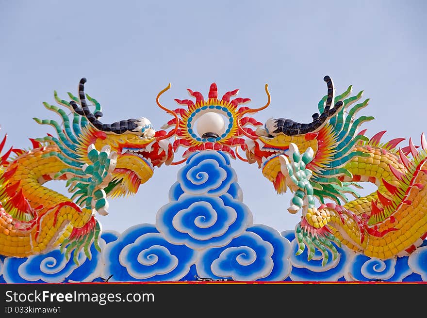 Two dragon statues in Chinese style on top of general temple roof. Two dragon statues in Chinese style on top of general temple roof.