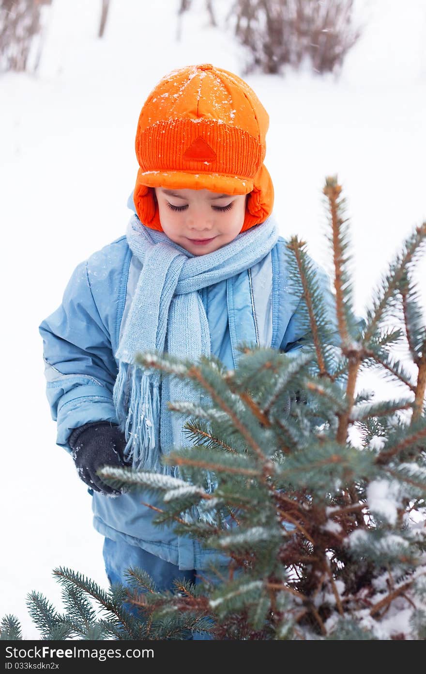 Little boy playing snowballs, snowman sculpts, digs snow. Holidays Christmas and New Year.