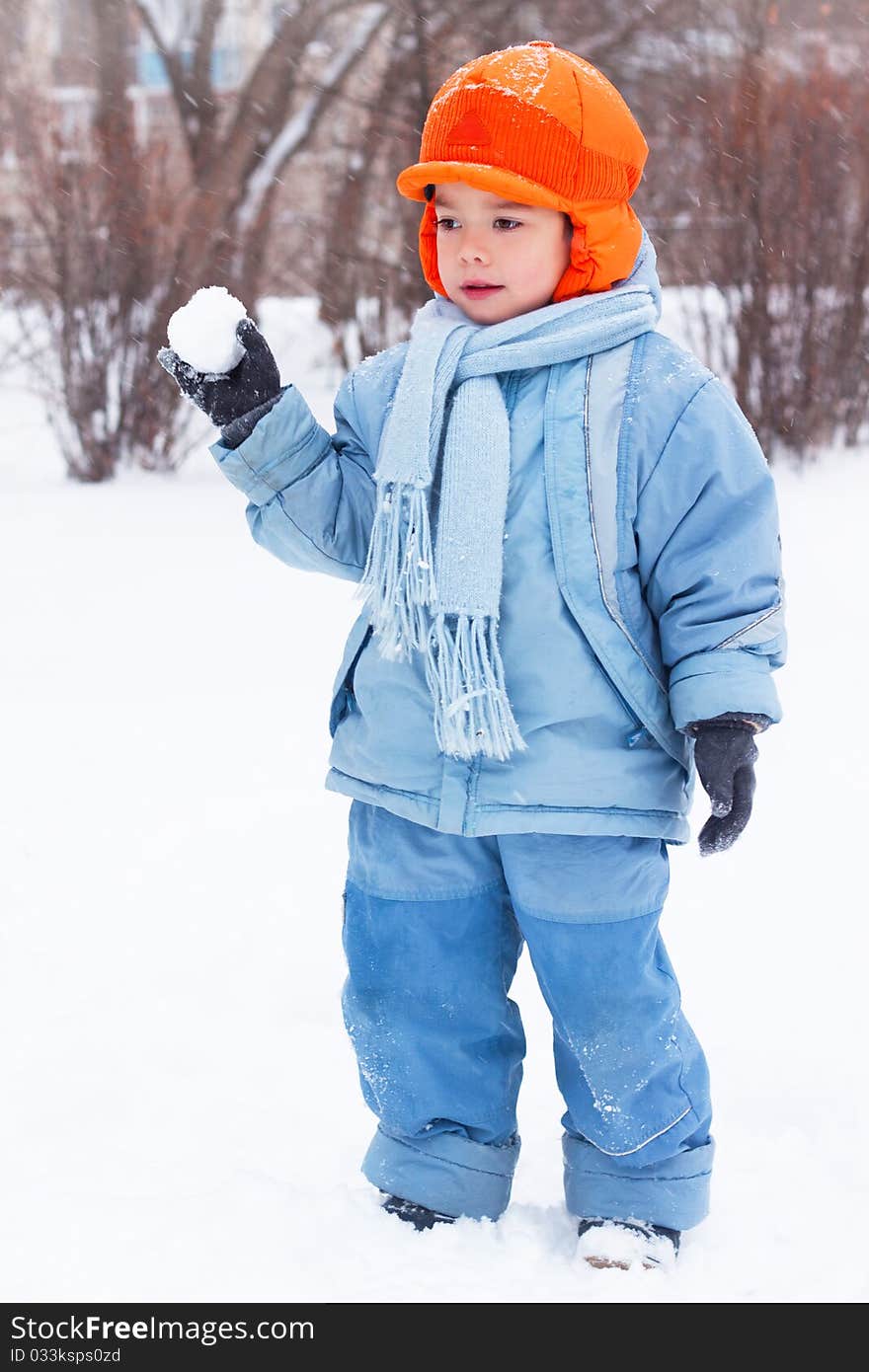 Little boy playing snowballs, snowman sculpts, digs snow. Holidays Christmas and New Year.