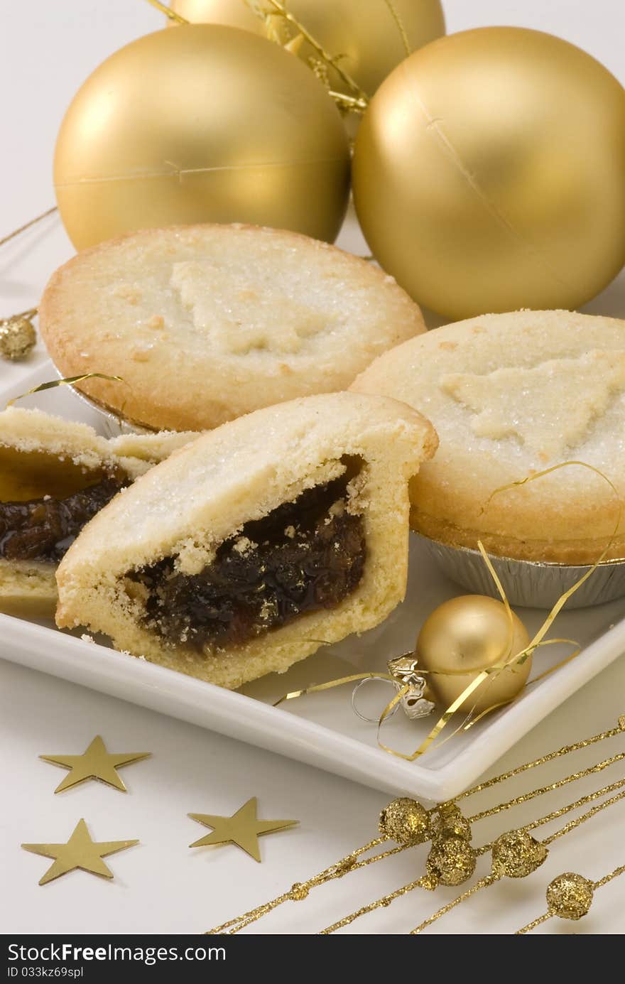 Homemade mince pies on white plate and Christmas ornaments. Homemade mince pies on white plate and Christmas ornaments.