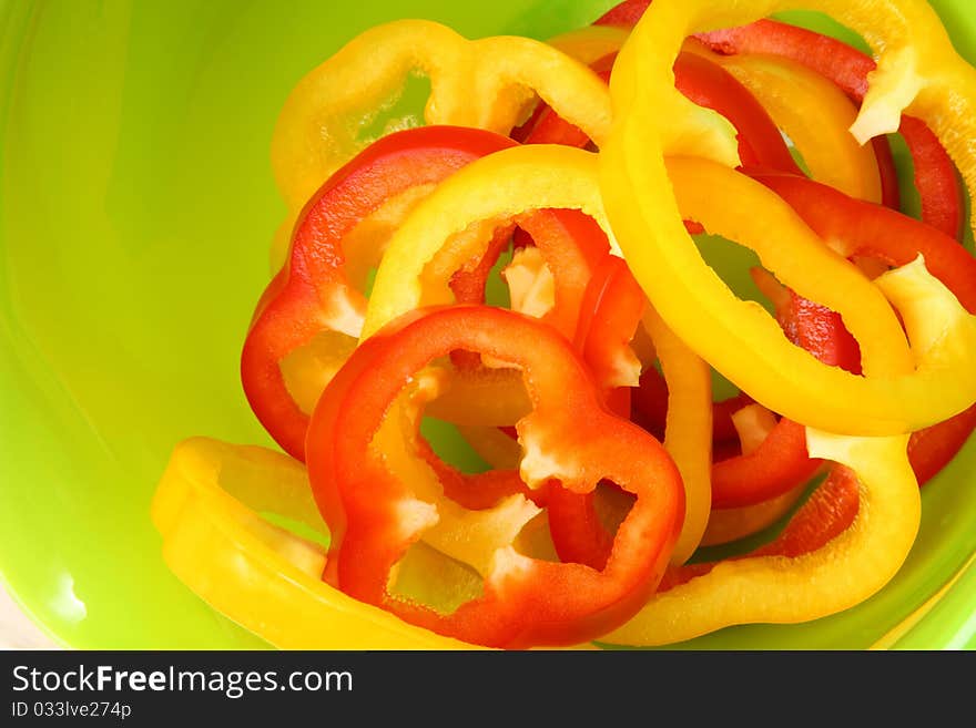 Sliced sweet peppers on bright green background