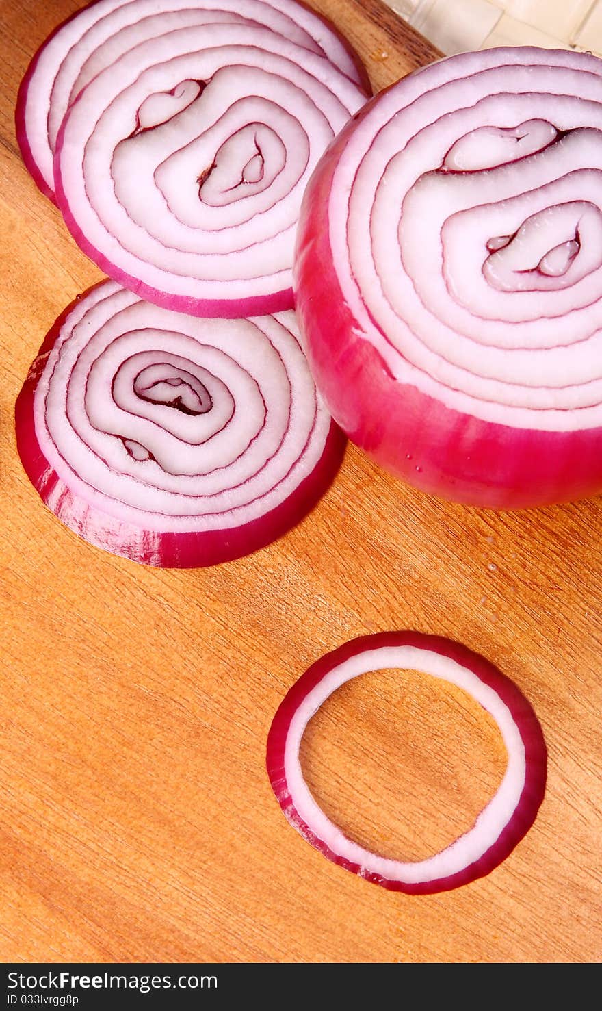 Image of sliced red onion over wooden hard board