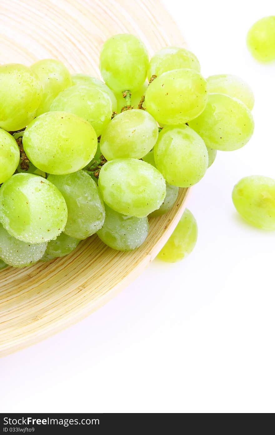 Grape on wooden plate over white